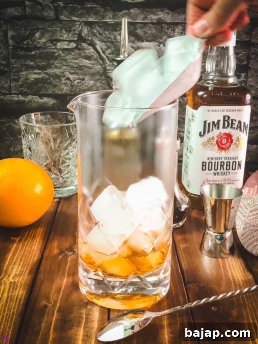 Adding cubed ice to the stirring glass with the liquid ingredients.