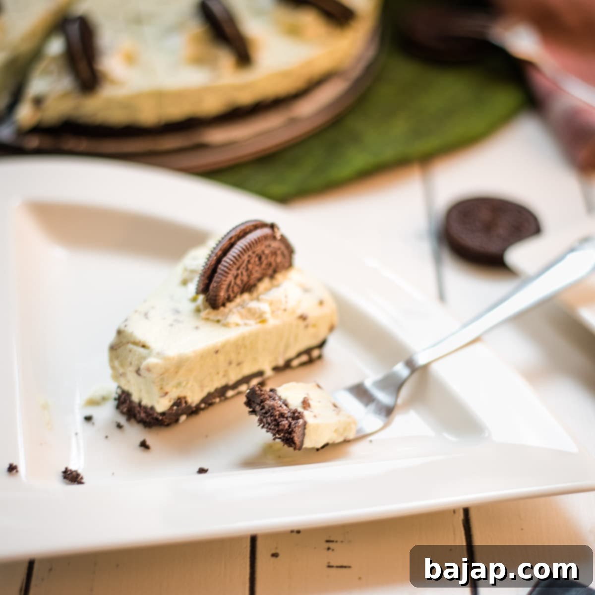 A refreshing green no bake mint chocolate cheesecake with Oreo crust and After Eight pieces inside the cream cheese filling.