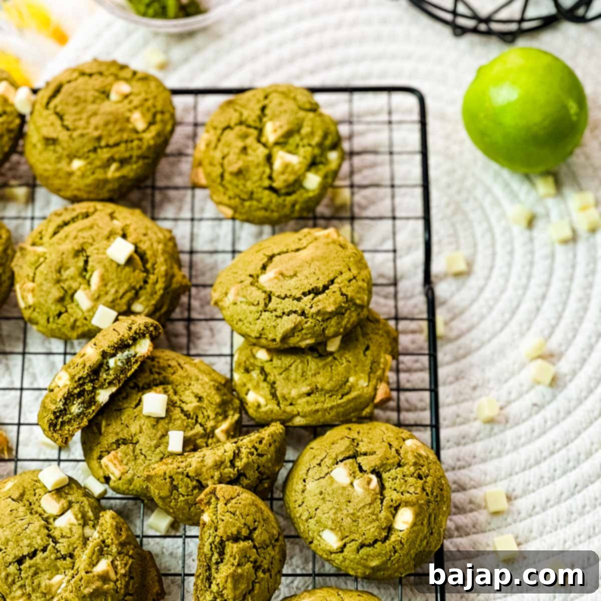Delicious white chocolate chip Matcha cookies with a hint of lime flavor - chewy and soft at the same time. Placed on a cooing rack.