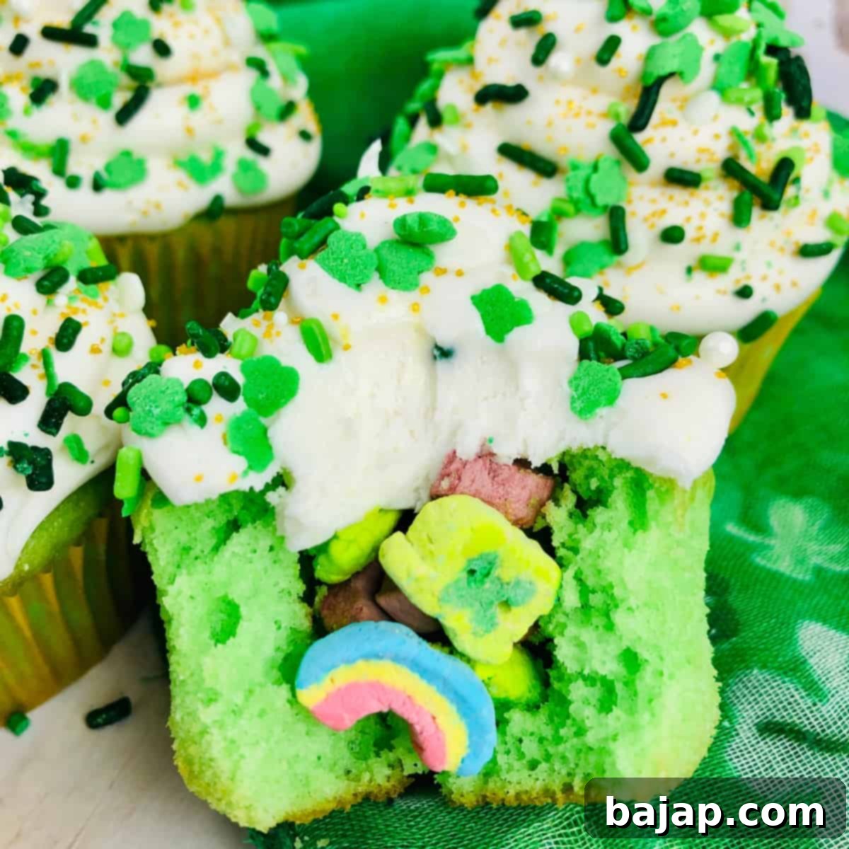 Whimsical Lucky Charms Cupcakes with a hidden cereal surprise, featuring green frosting and colorful marshmallows, ideal for St. Patrick's Day.