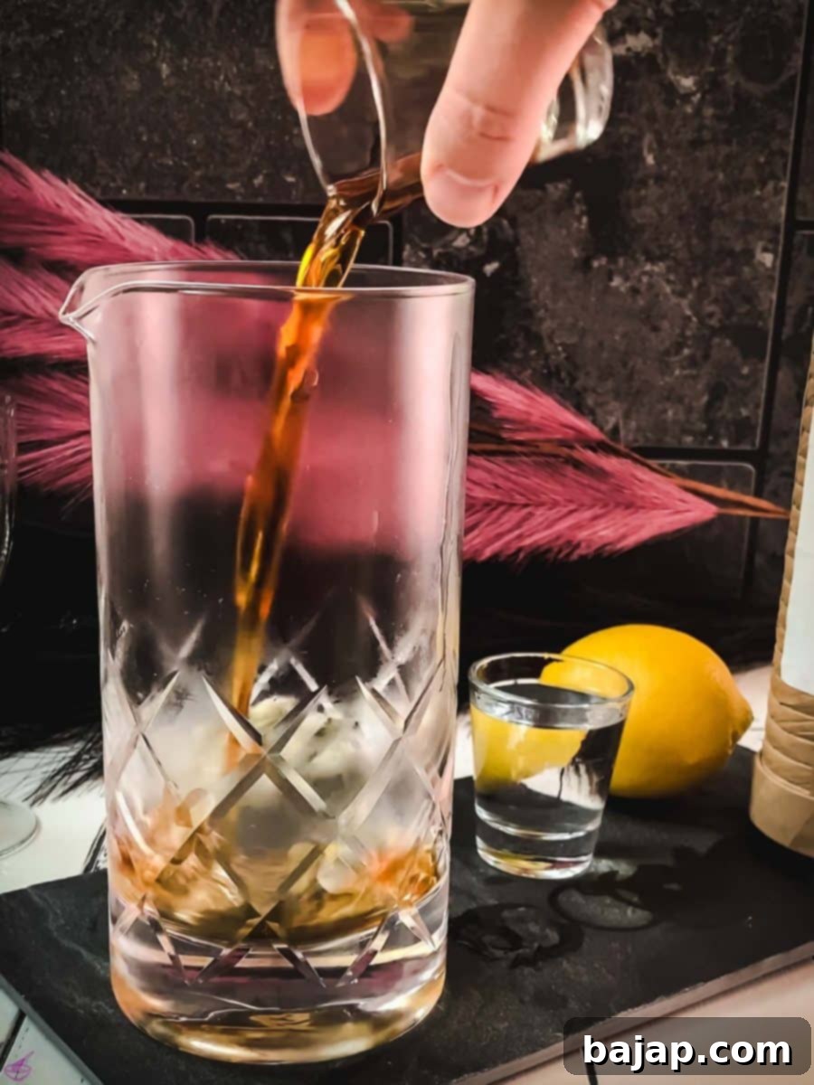 Pouring the specified amount of sweet vermouth into the mixing glass, an essential component for a balanced Martinez cocktail.
