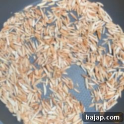 Almond slivers roasting in a non-stick frying pan until golden brown