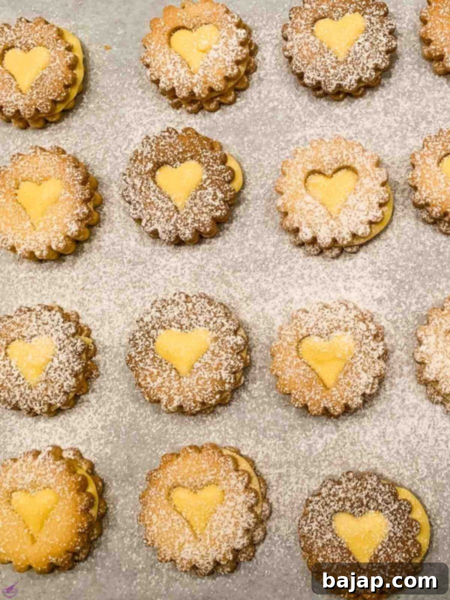 Egg Liqueur Infused Linzer Cookies 15 Close-up of ready-to-eat Linzer Cookies with homemade Advocaat Egg Liqueur ganache, dusted with powdered sugar.
