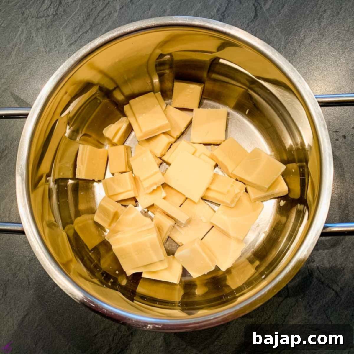Break white chocolate couverture into pieces.