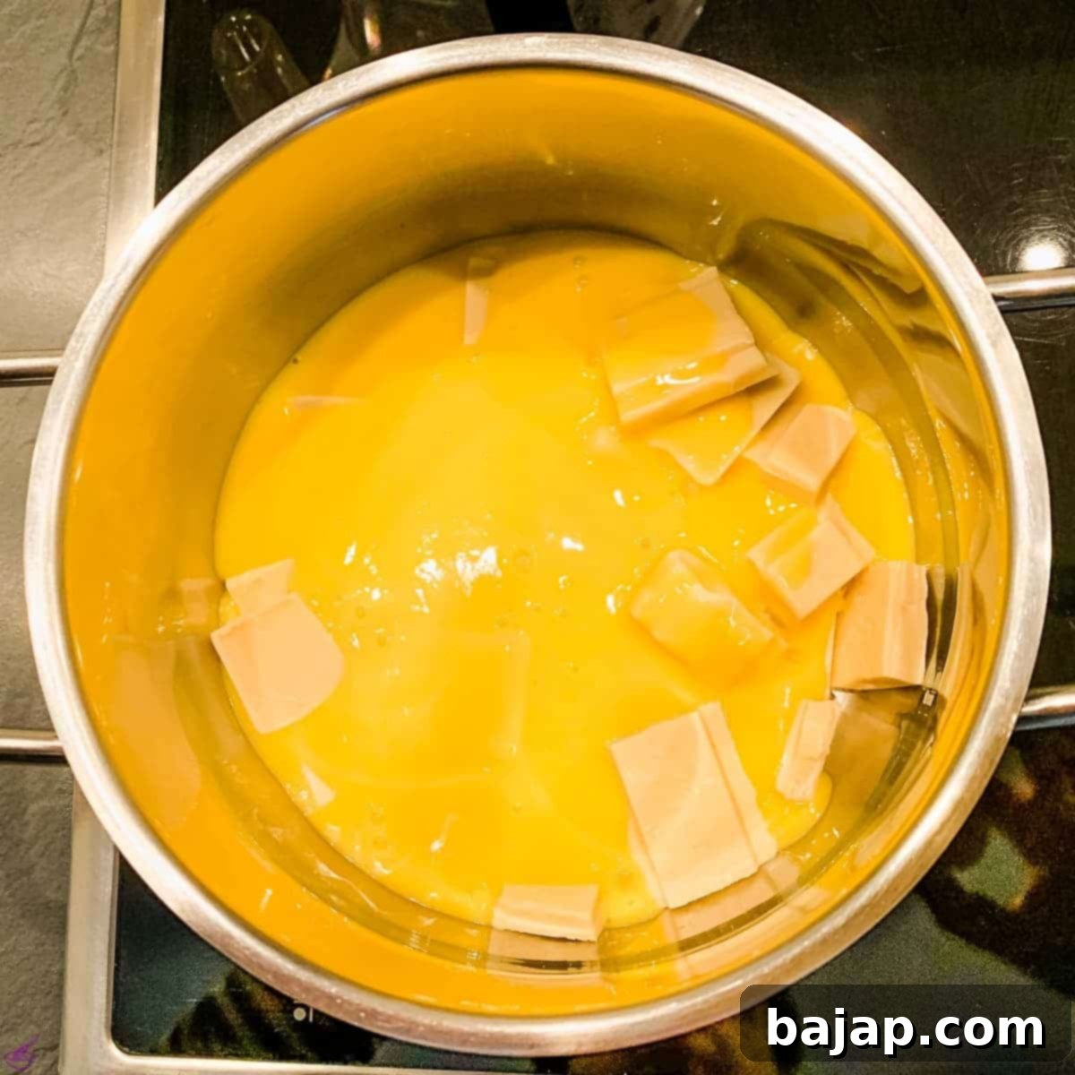 Pour the hot eggnog over the white couverture.