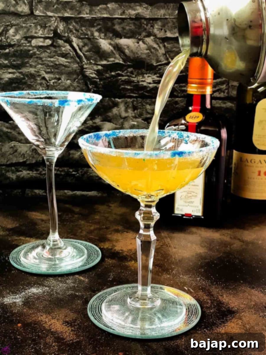 Pouring the mixed Whiskey Sidecar into the prepared cocktail glass.
