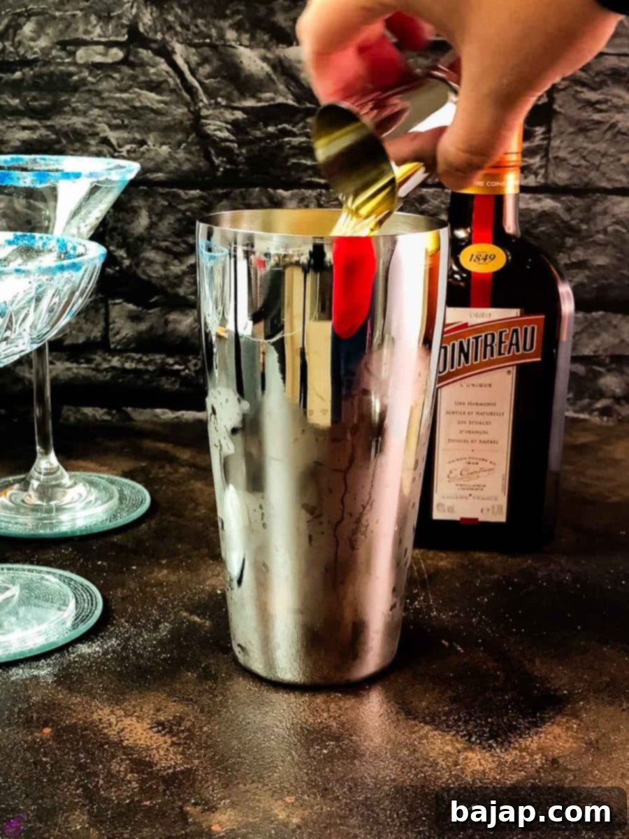 Adding whiskey to the cocktail shaker.