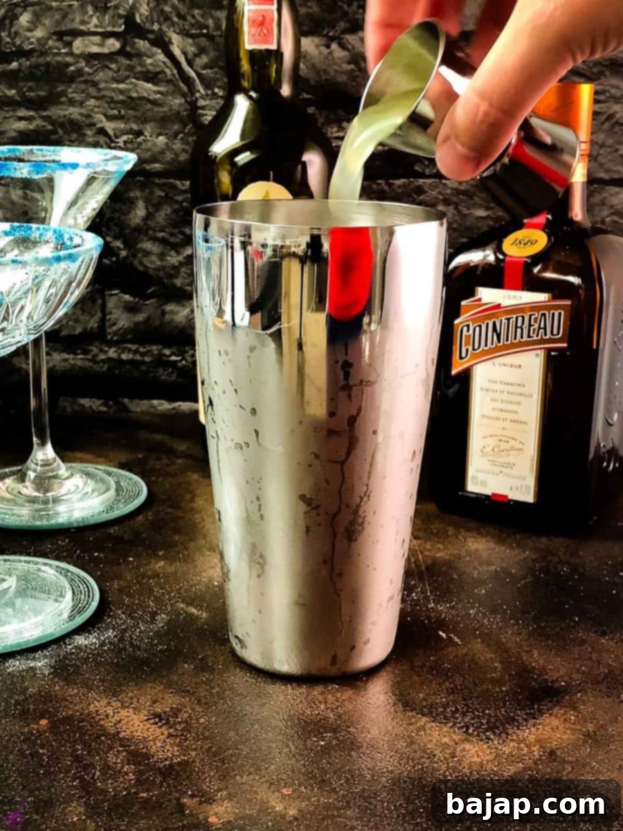 Adding fresh lemon juice to the cocktail shaker.