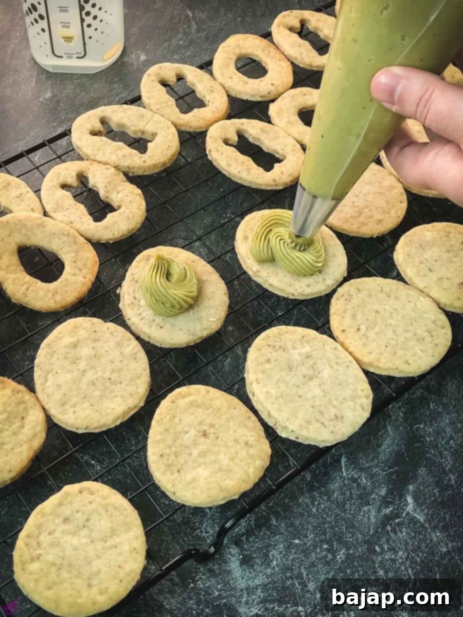 Pipe the pistachio ganache on every cut out cookie without a motif.