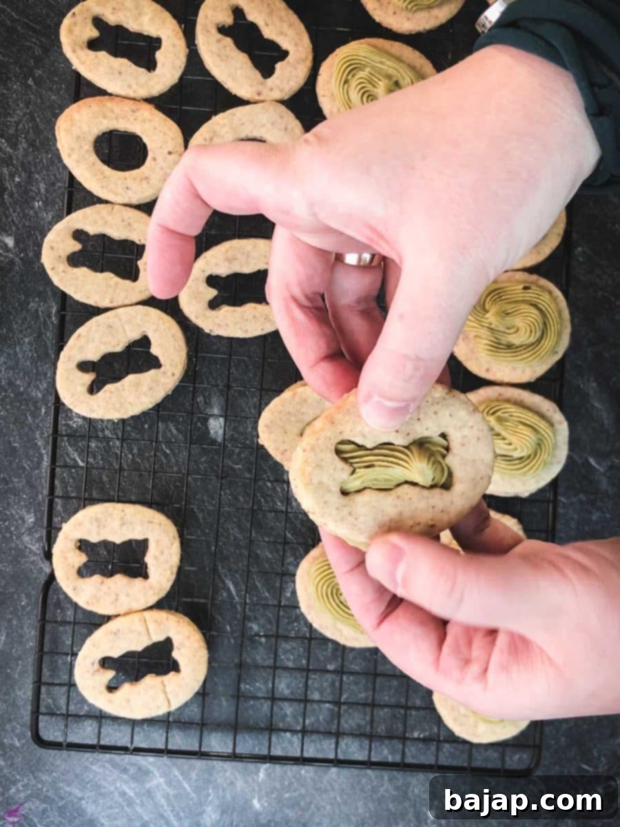 Carefully place the cut-out motif cookie on top of the pistachio ganache.