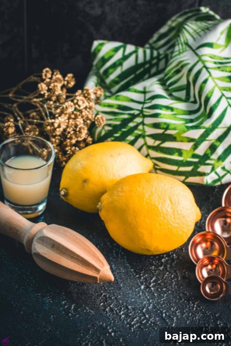 Lemons, placed on dark ground next to lemon juice and lemon squeezer.