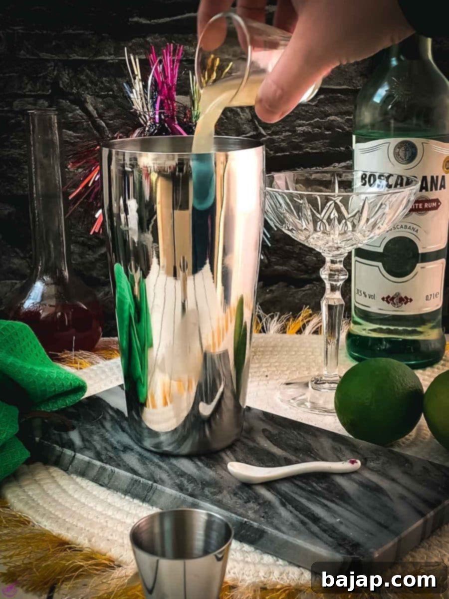 Add lime juice to a cocktail shaker with rum and raspberry syrup.