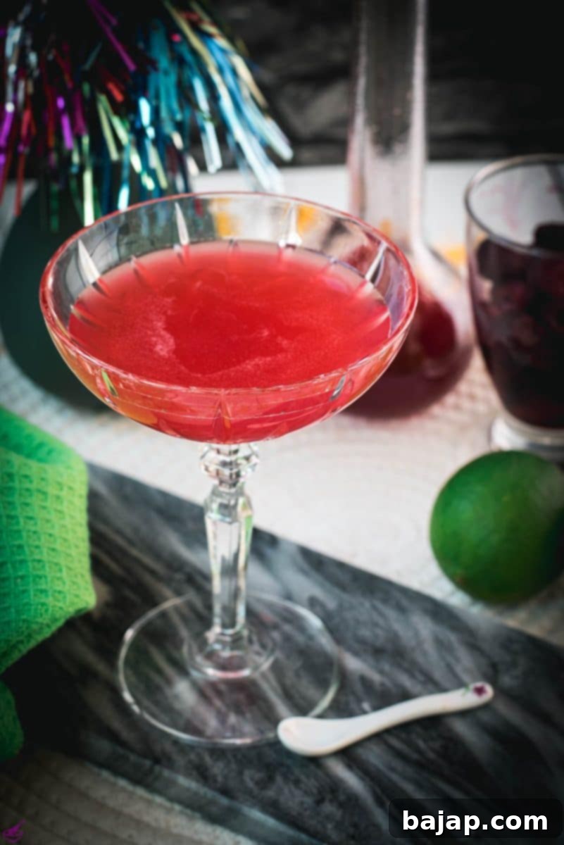 Gorgeous raspberry daiquiri with a vibrant red color placed on marble plate, highlighting its elegant simplicity.
