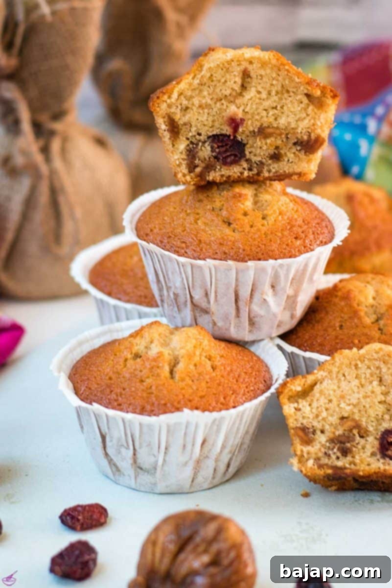 Delicious, and very easy to make, fruit cake muffins, filled with dried figs and dried cranberries. Placed on white plate.