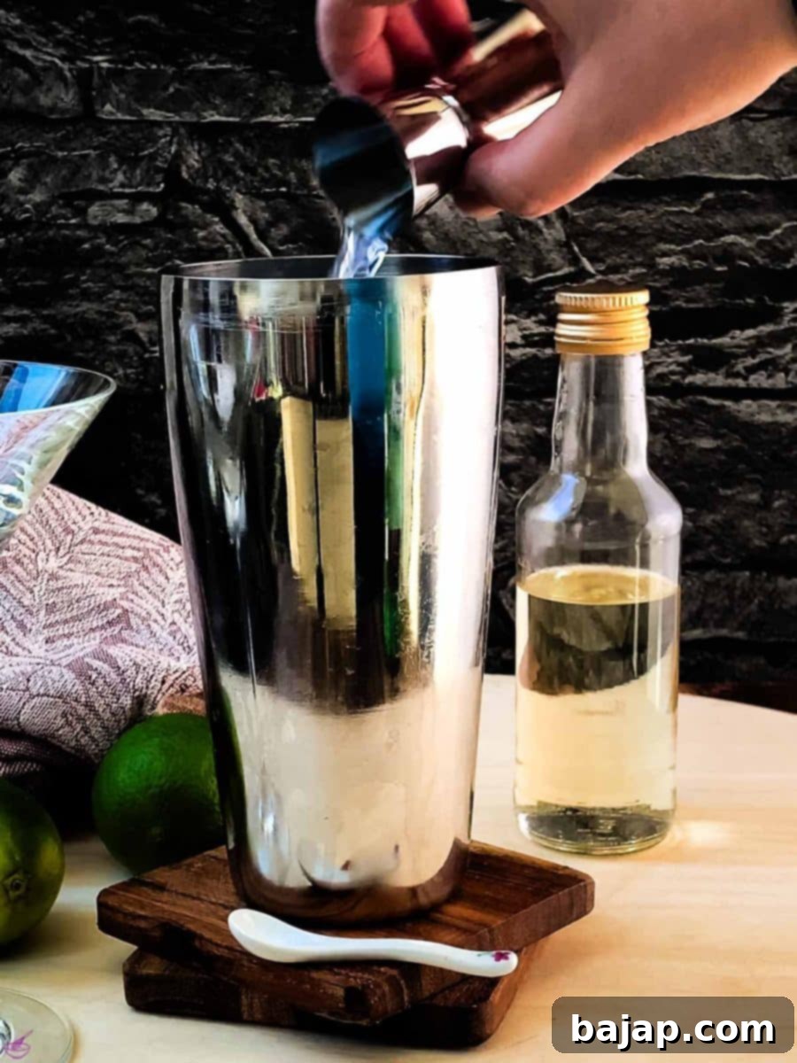 Add white rum to the cocktail shaker. Measure carefully for the perfect balance.