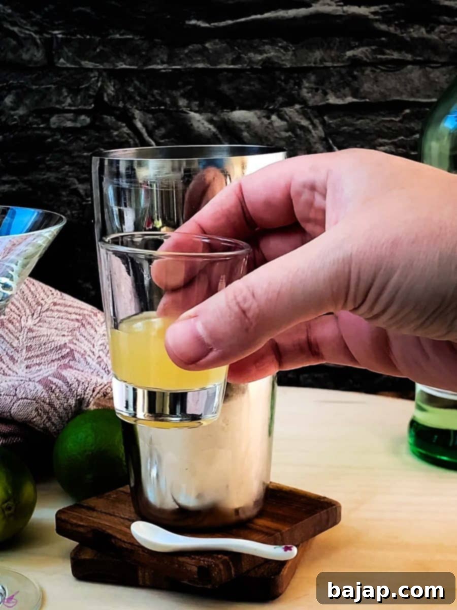 Add lime juice to the cocktail shaker. Freshly squeezed lime juice is crucial for the best flavor.