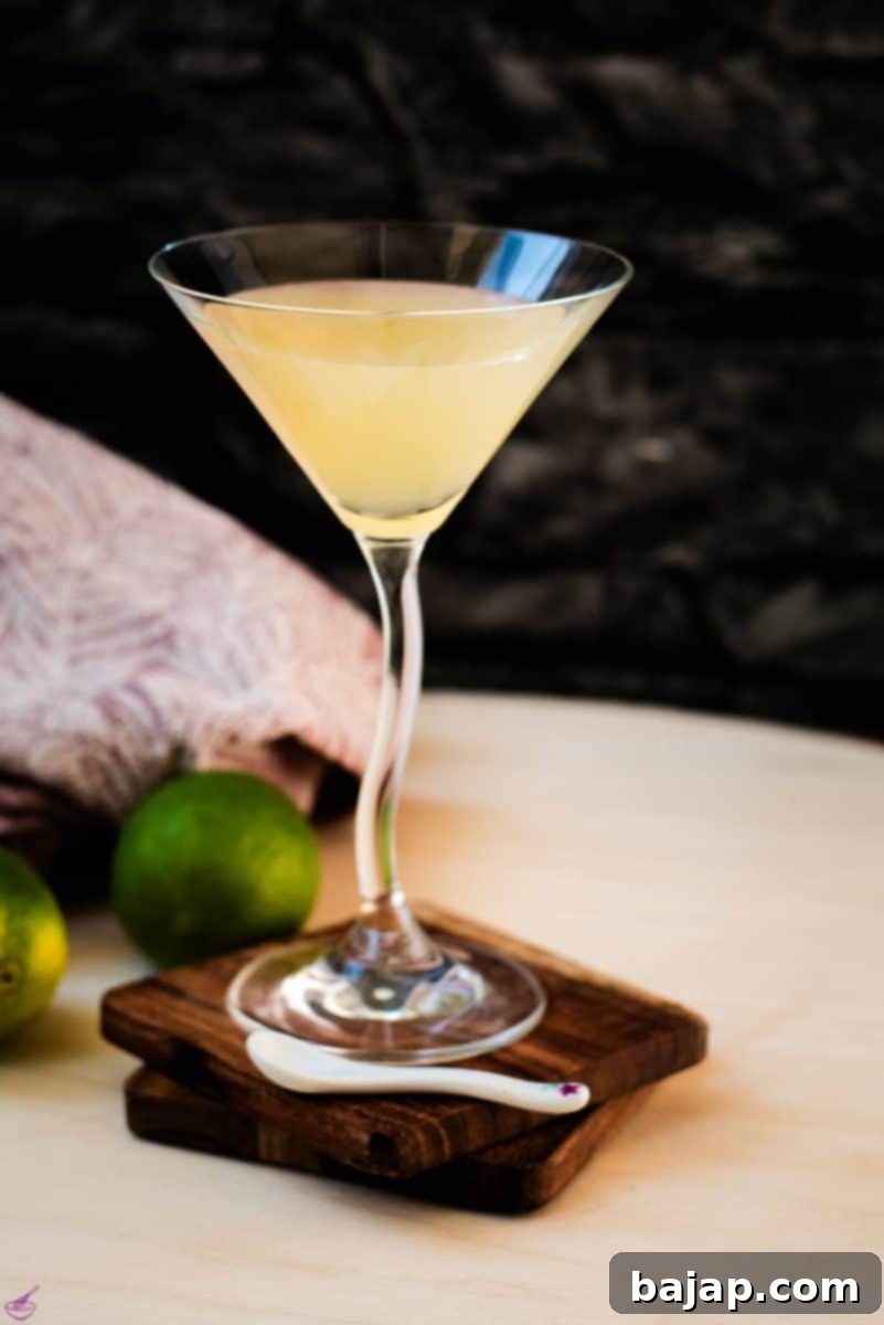 Gorgeous colored daiquiri in cocktail glass. Placed on a wooden board and dark wooden coaster. Ready for enjoyment.