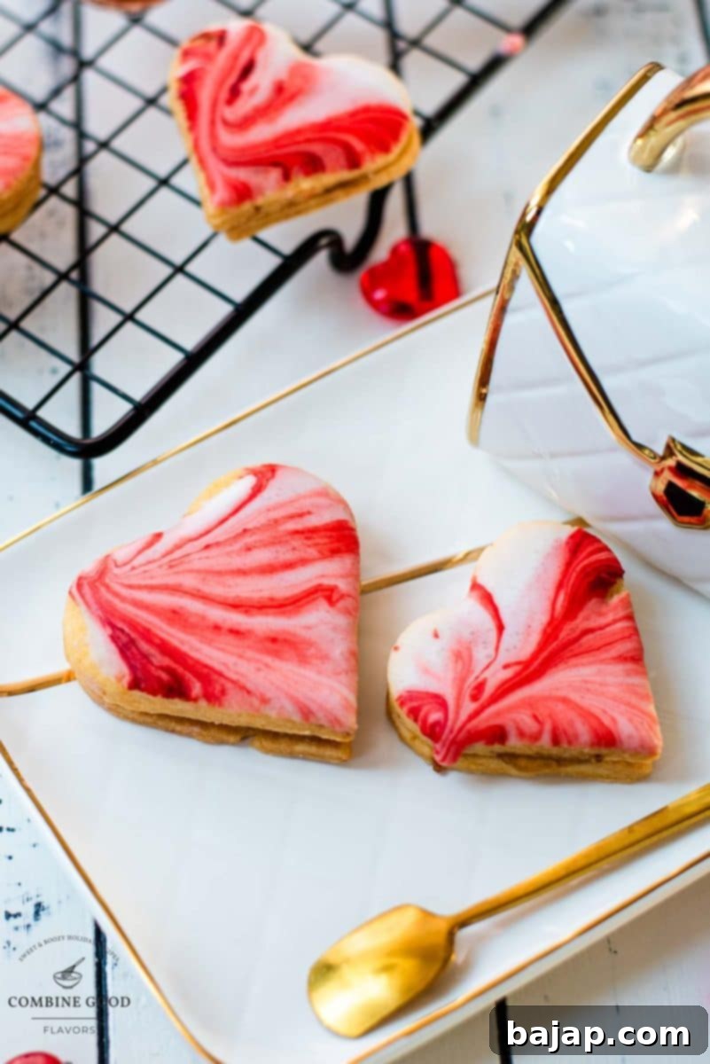 Gorgeous heart shaped sugar cookies with marbled icing, and filled with fig jam. Placed on gorgeous white golden serving plate.