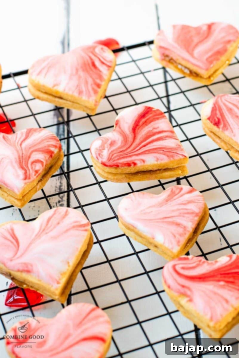 Gorgeous heart shaped sugar cookies with marbled icing, and filled with fig jam. Placed on cooling rack.