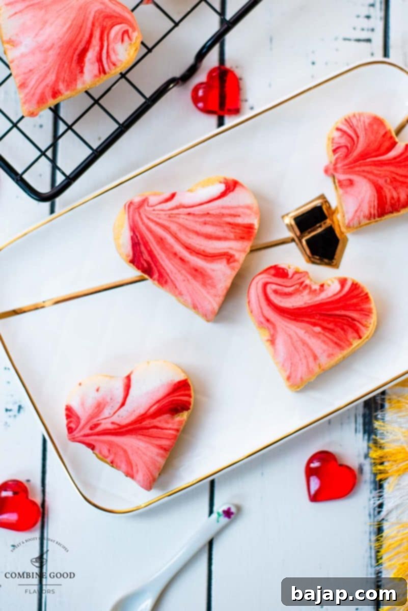 Gorgeous heart shaped sugar cookies with marbled icing, and filled with fig jam. Placed on gorgeous white golden serving plate.