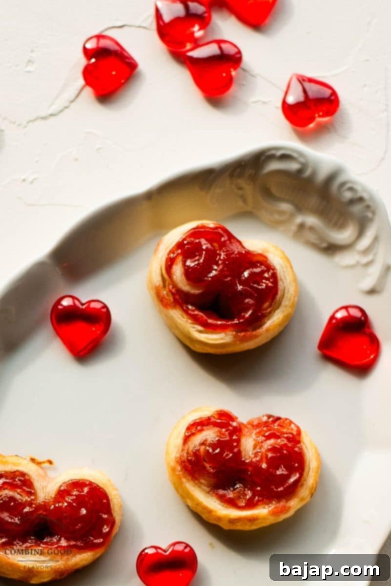 Beautiful puff pastry hearts with strawberry jam, trapped on an elegant, old serving platter. Decorated with glass hearts.