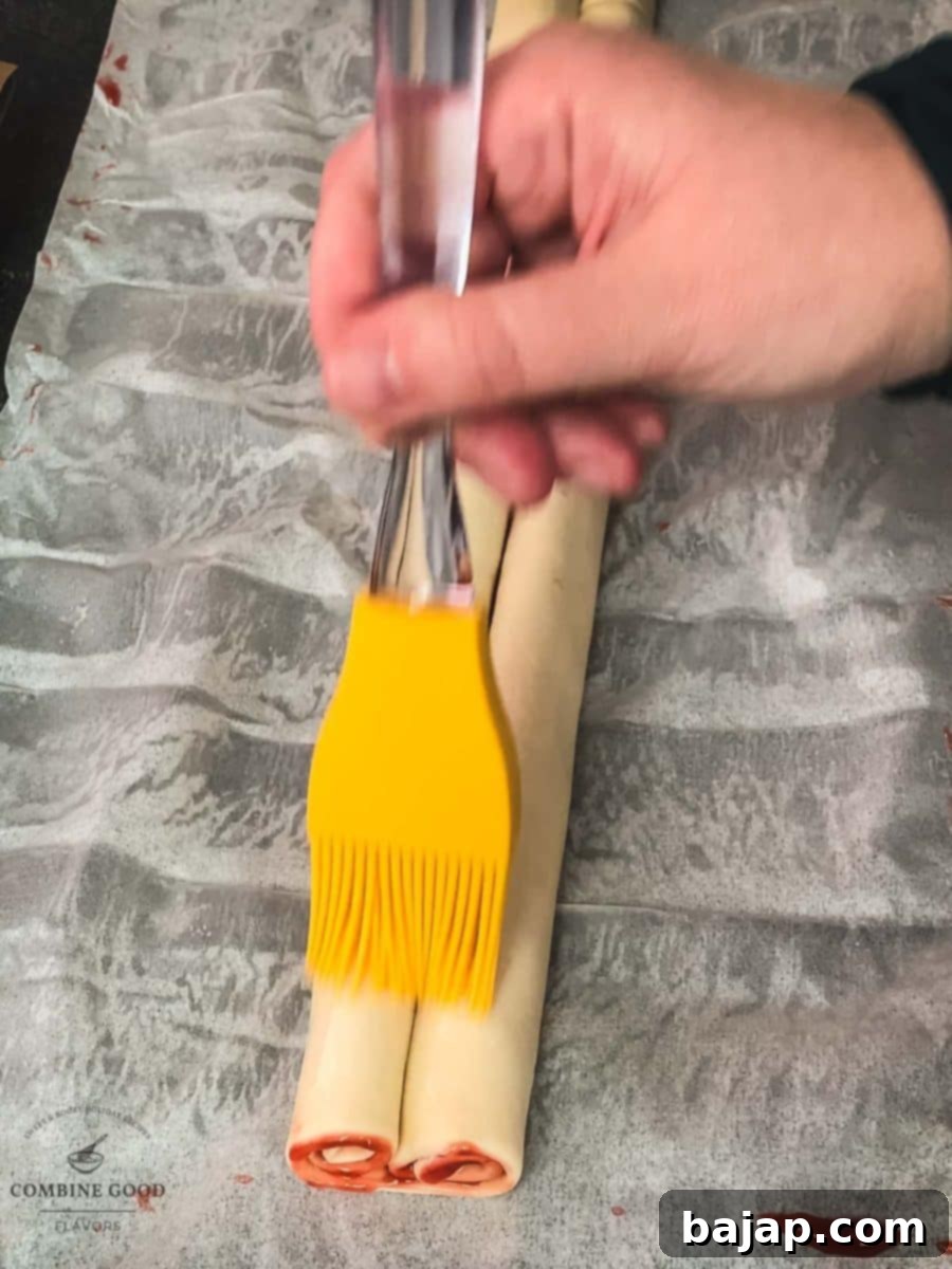 Brush the puff pastry roll with water.