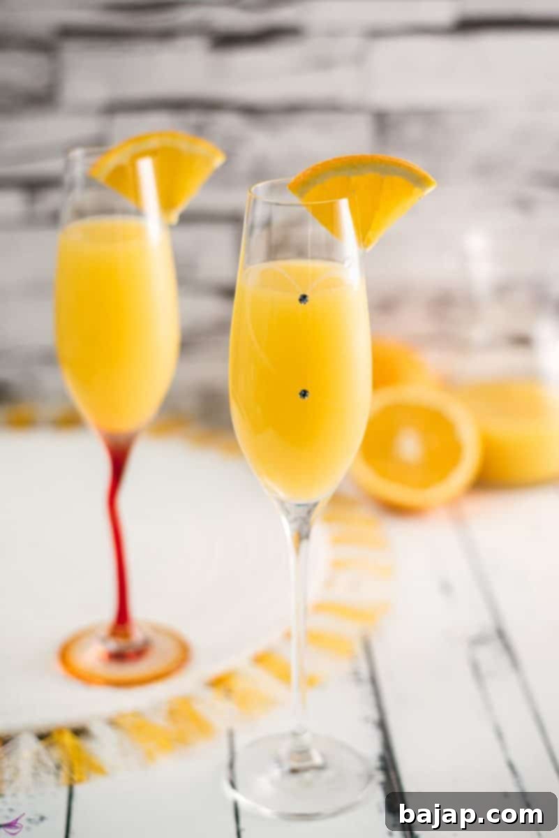 Gorgeous mimosa, garnished with orange slice in cute glass with small gems.