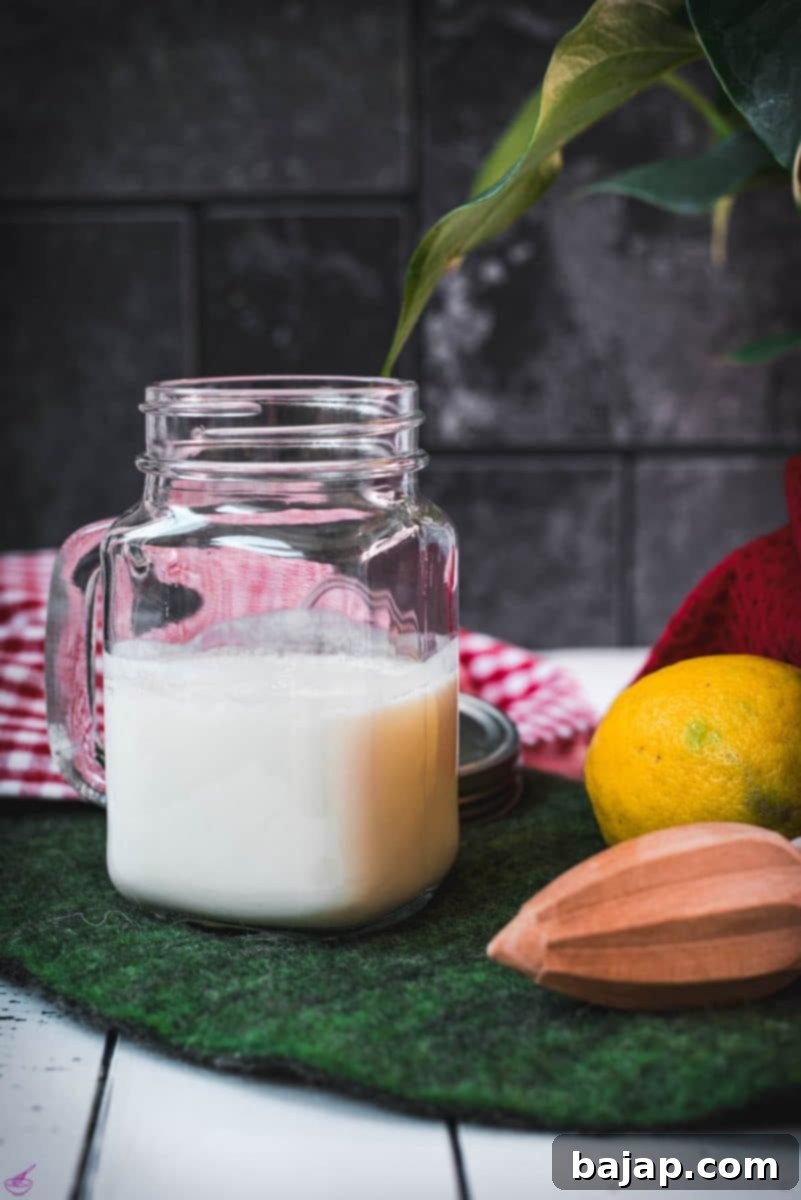 Ready to use homemade sour milk in a glass bottle, placed on a vibrant green felt mat, perfectly curdled and ready for baking.