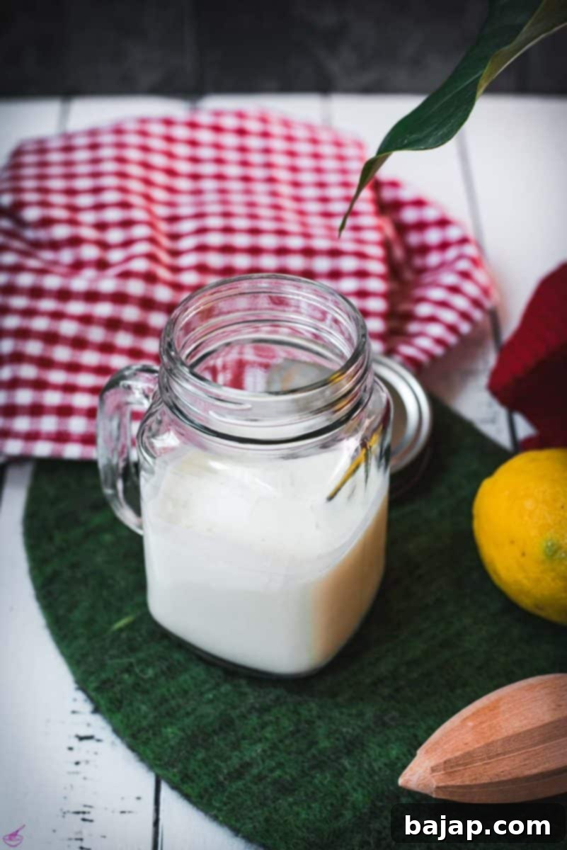 Finished homemade sour milk, perfectly curdled and ready to be used in baking, resting on a green felt mat with a spoon.