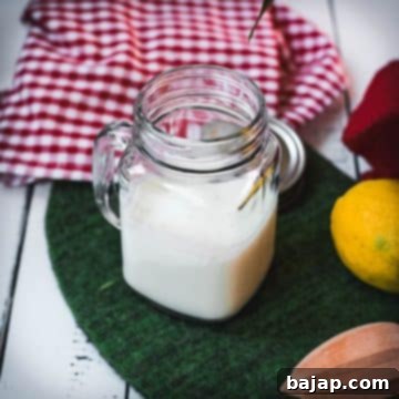 Glass bottle of homemade sour milk on a green mat, ready for use in baking.