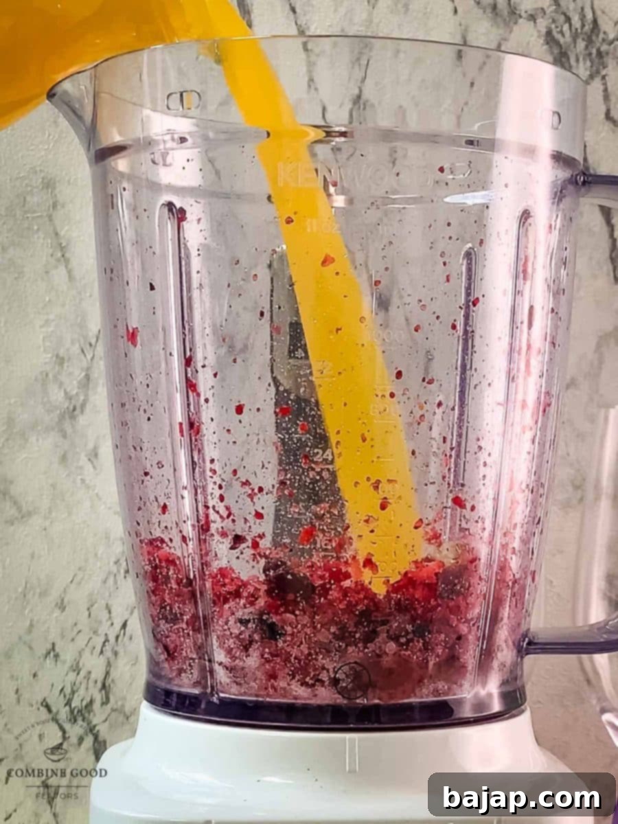 Pour fresh orange juice into the blender with berries and sugar for the mimosa base.