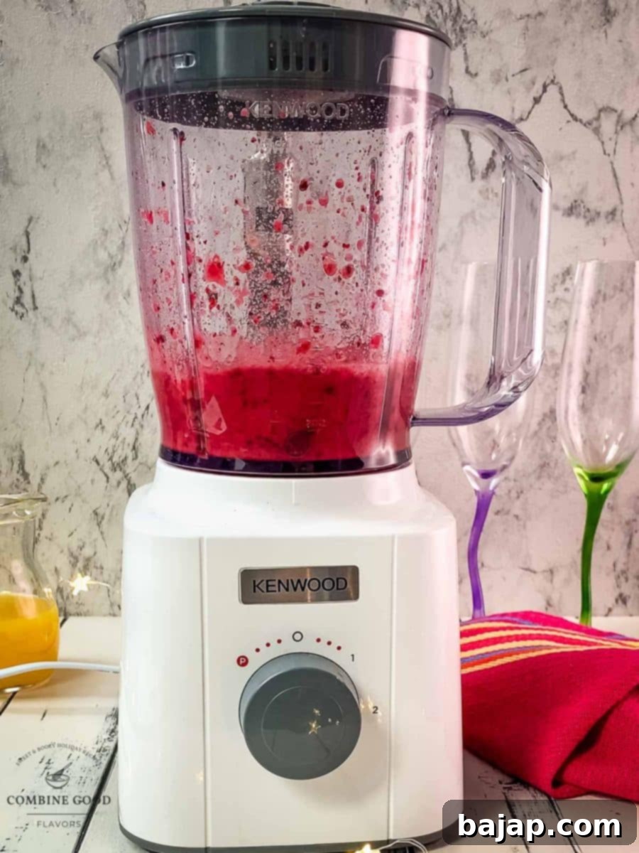 Blend the berry mix, sugar, and orange juice until completely smooth and ready for mimosa assembly.