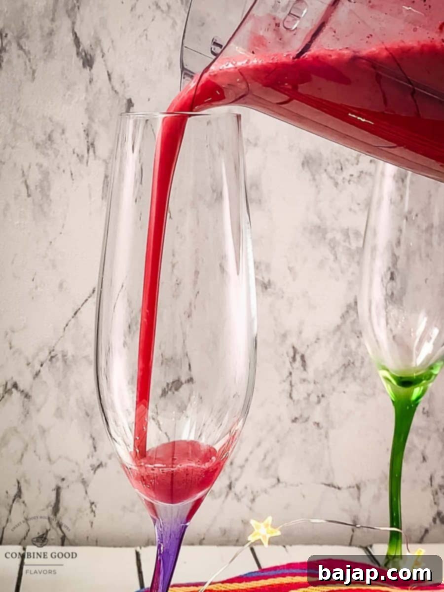 Fill champagne glasses halfway with the vibrant berry smoothie base, preparing for the sparkling wine.