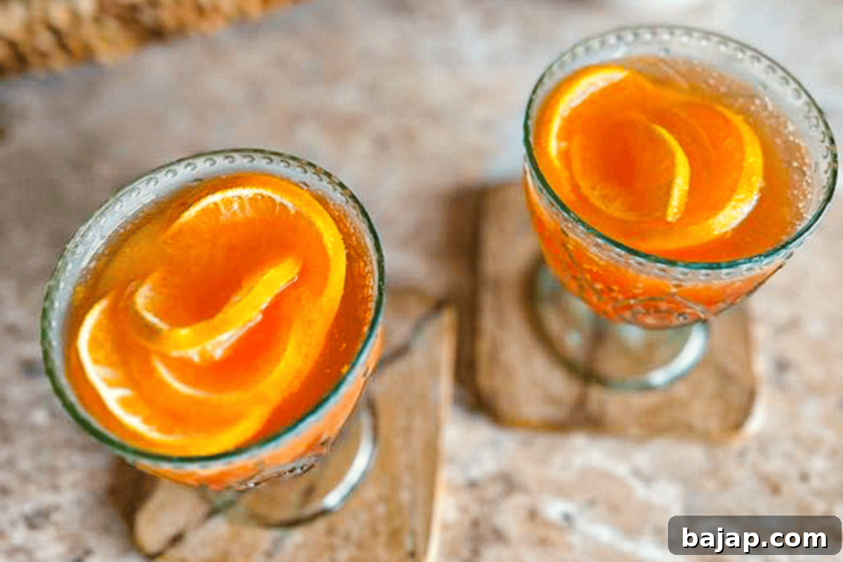 A vibrant Aperol Mimosa garnished with elegant frozen orange roses, perfect for special occasions like Mother's Day.