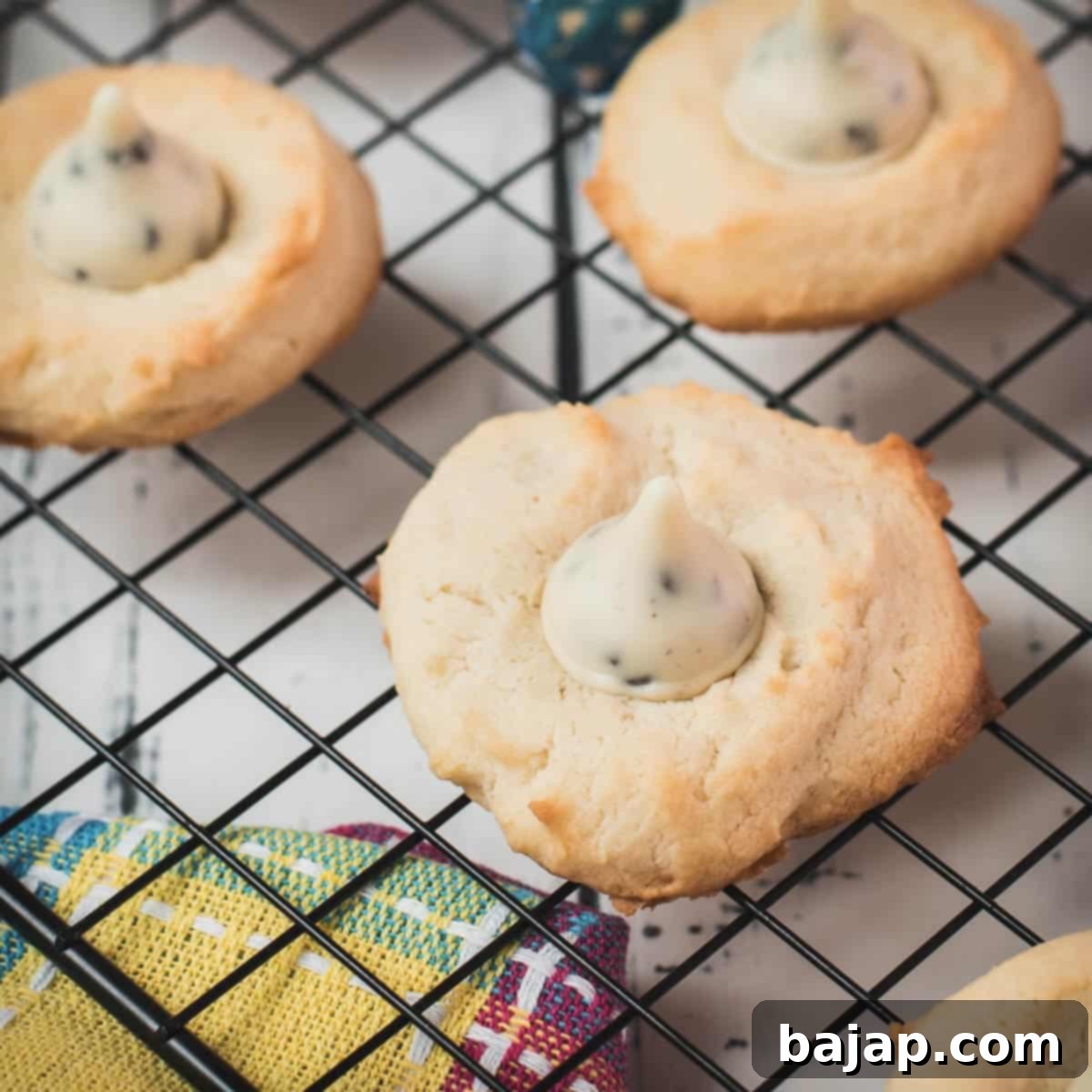 Gorgeous Cookies 'n Cream Blossom Cookies placed on cooling rack, combining cream cheese and Hershey Kisses.