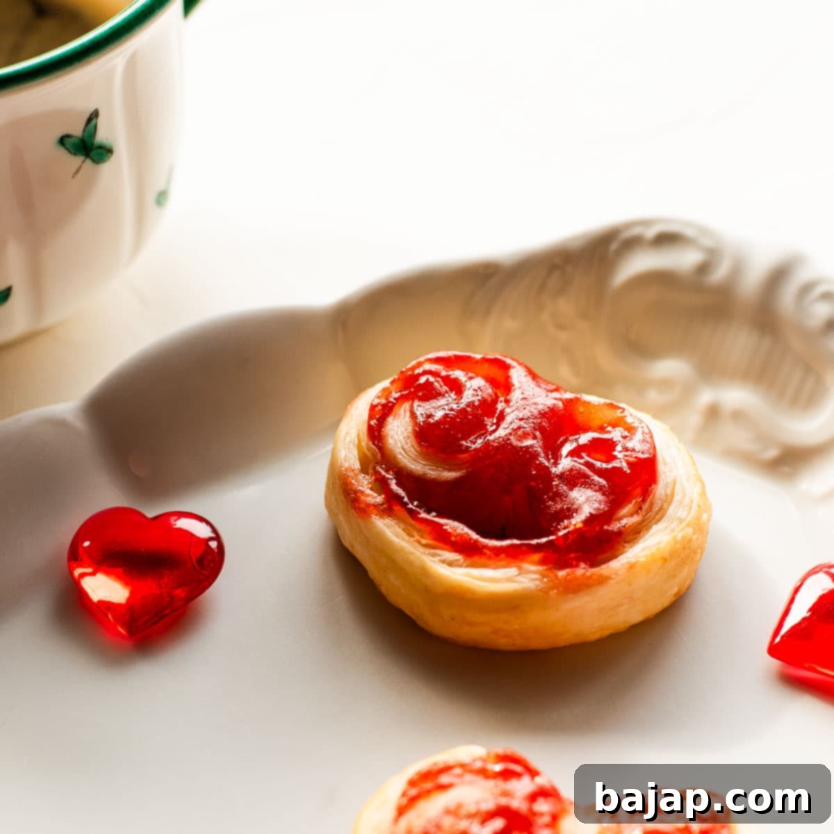 Beautiful puff pastry hearts with strawberry jam, trapped on an elegant, old serving platter. Decorated with glass hearts.