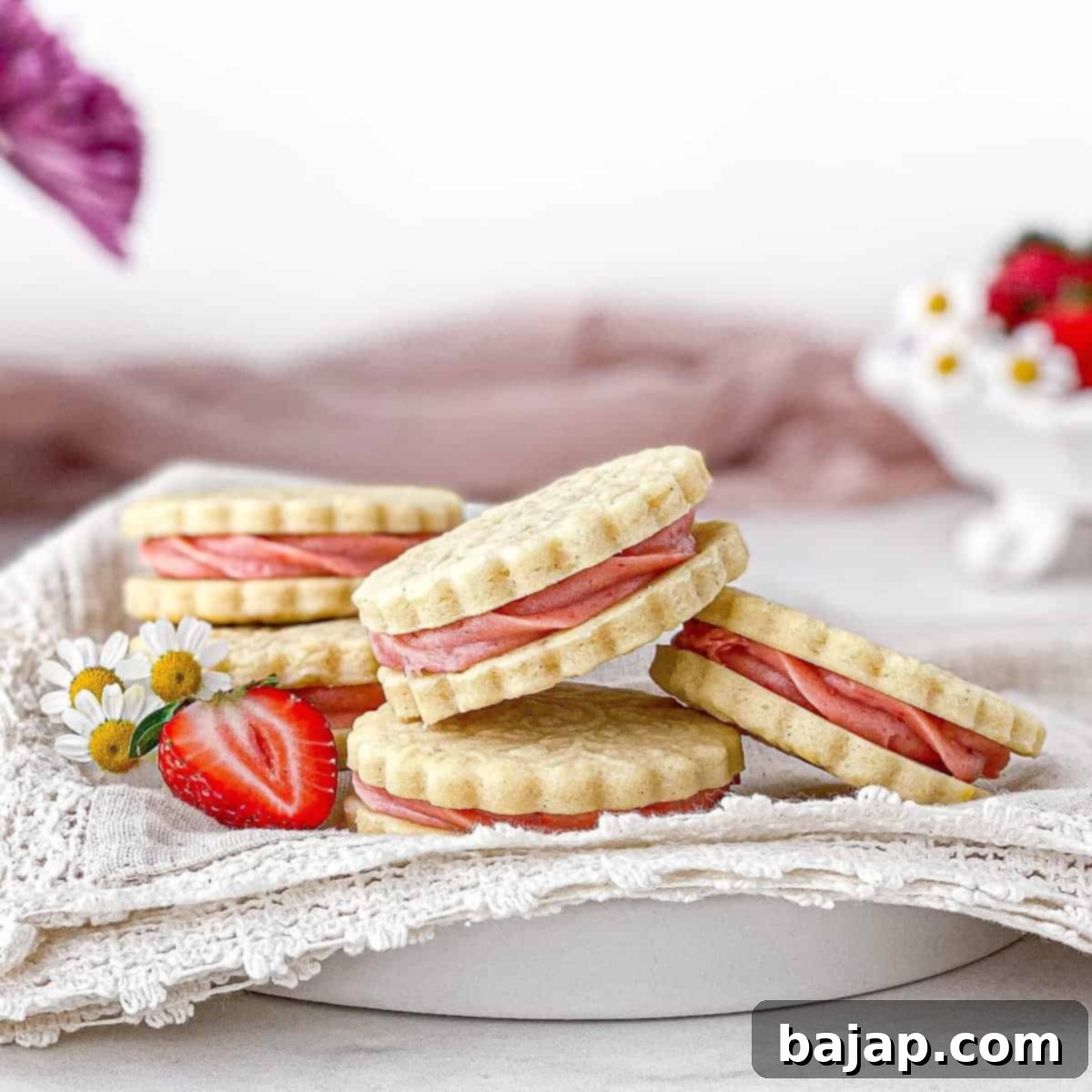 Delightful Strawberry Cheesecake Cookies on a plate, featuring swirls of strawberry cream cheese frosting.