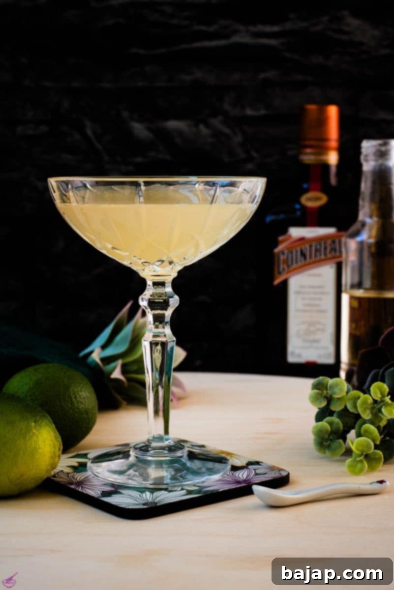 Gorgeous silky Margarita, served in cocktail glass and placed on coaster with flower pattern.