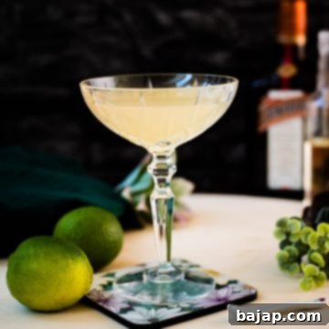 Gorgeous silky Margarita, served in cocktail glass and placed on coaster with flower pattern.