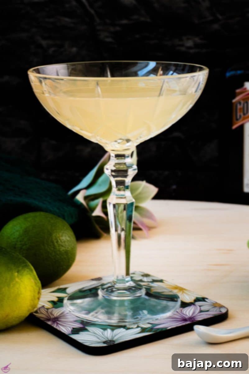 Gorgeous silky Margarita, served in cocktail glass and placed on coaster with flower pattern.