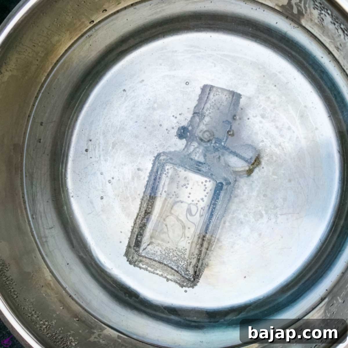 Sterilizing glass bottles in a pot of boiling water, a vital step for safe homemade food products.