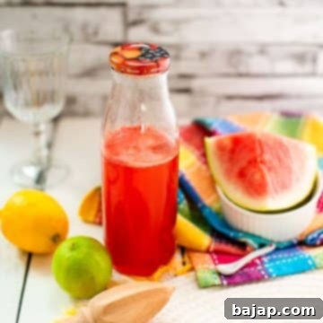 Preserving bottle filled with vibrant watermelon syrup, displayed on a wooden background.