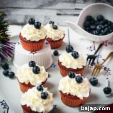 Gorgeous red, white and blue cupcakes, placed on white plate. The muffin sponge in red, crème fraîche cream in white, and blueberries as the blue accent.