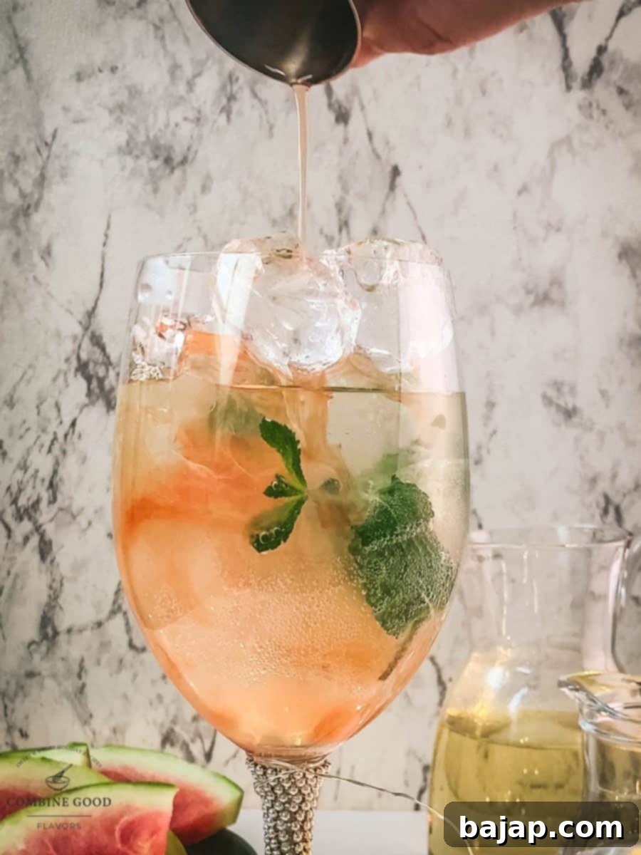 Adding watermelon syrup to the wine glass using a jigger.