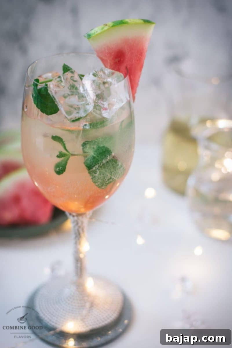 Gorgeous wine glass filled with watermelon spritzer, with a blurred background of summer vibes.