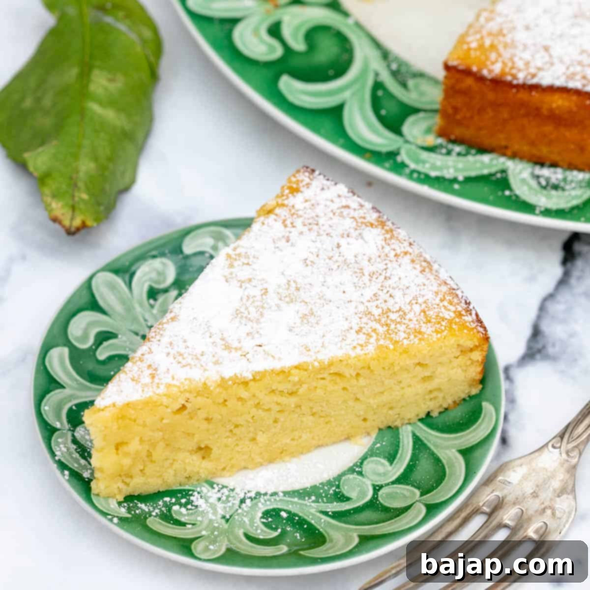 Moist Lemon Ricotta Cake slice on a white plate with a fork