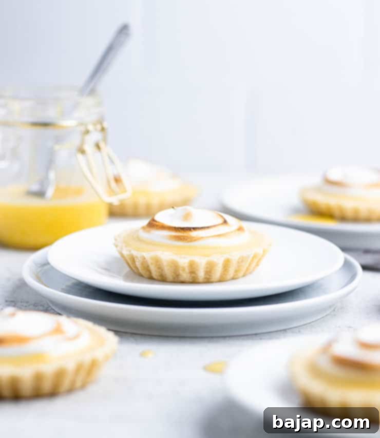 Individual lemon meringue tartlets with toasted meringue peaks.