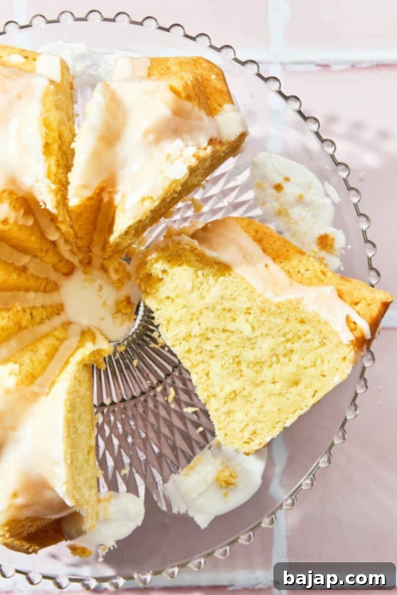 Elegant lemon sour cream bundt cake on a white cake stand.
