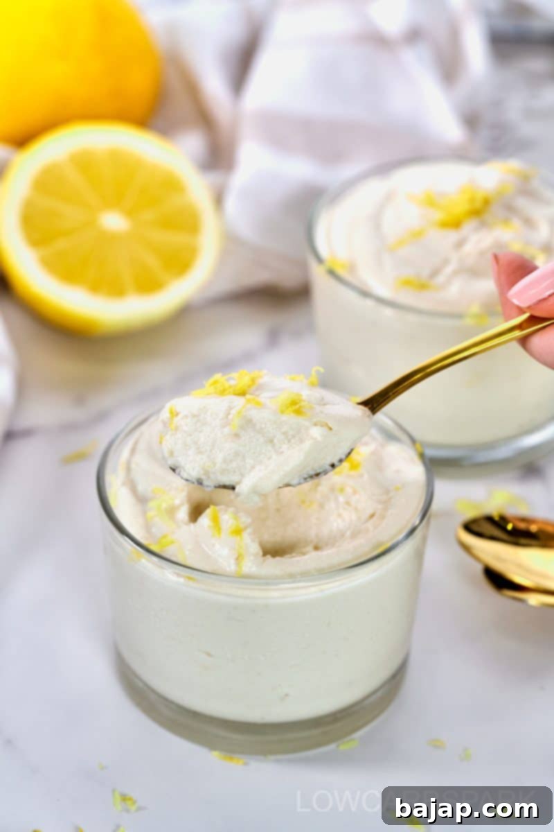 Creamy cottage cheese lemon mousse in a glass bowl with fresh lemon.