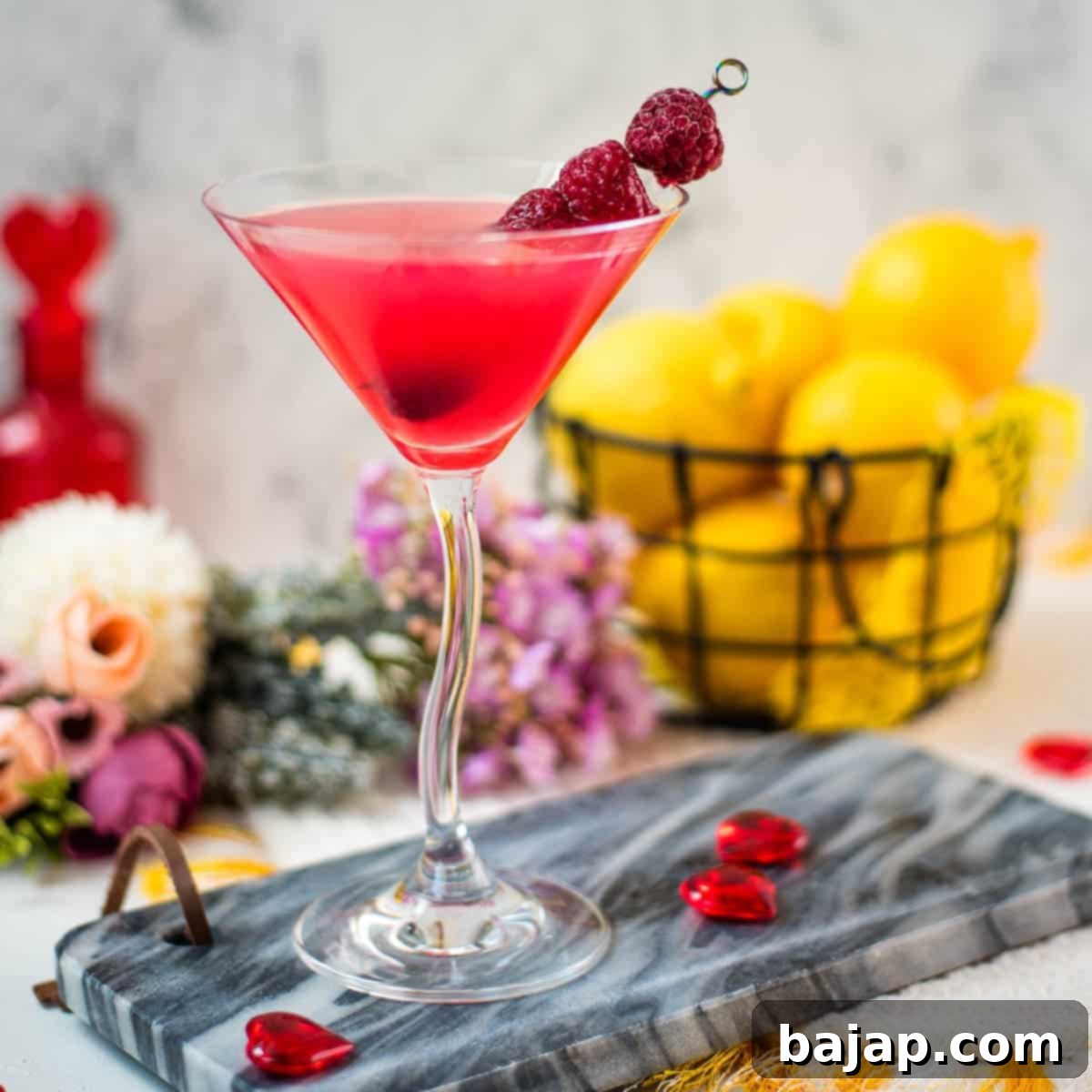 Cocktail glass with a Raspberry Lemon Drop Martini, garnished with fresh raspberries.